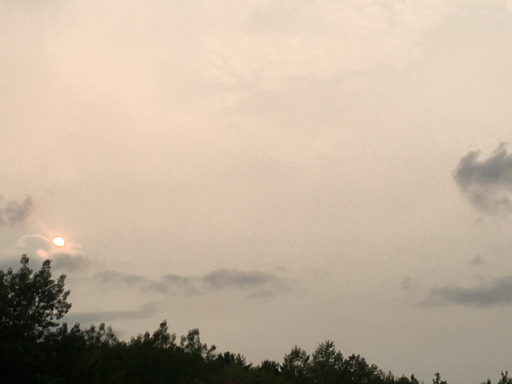 Hazy view of the sun impacted by smoke from wildfires. 
