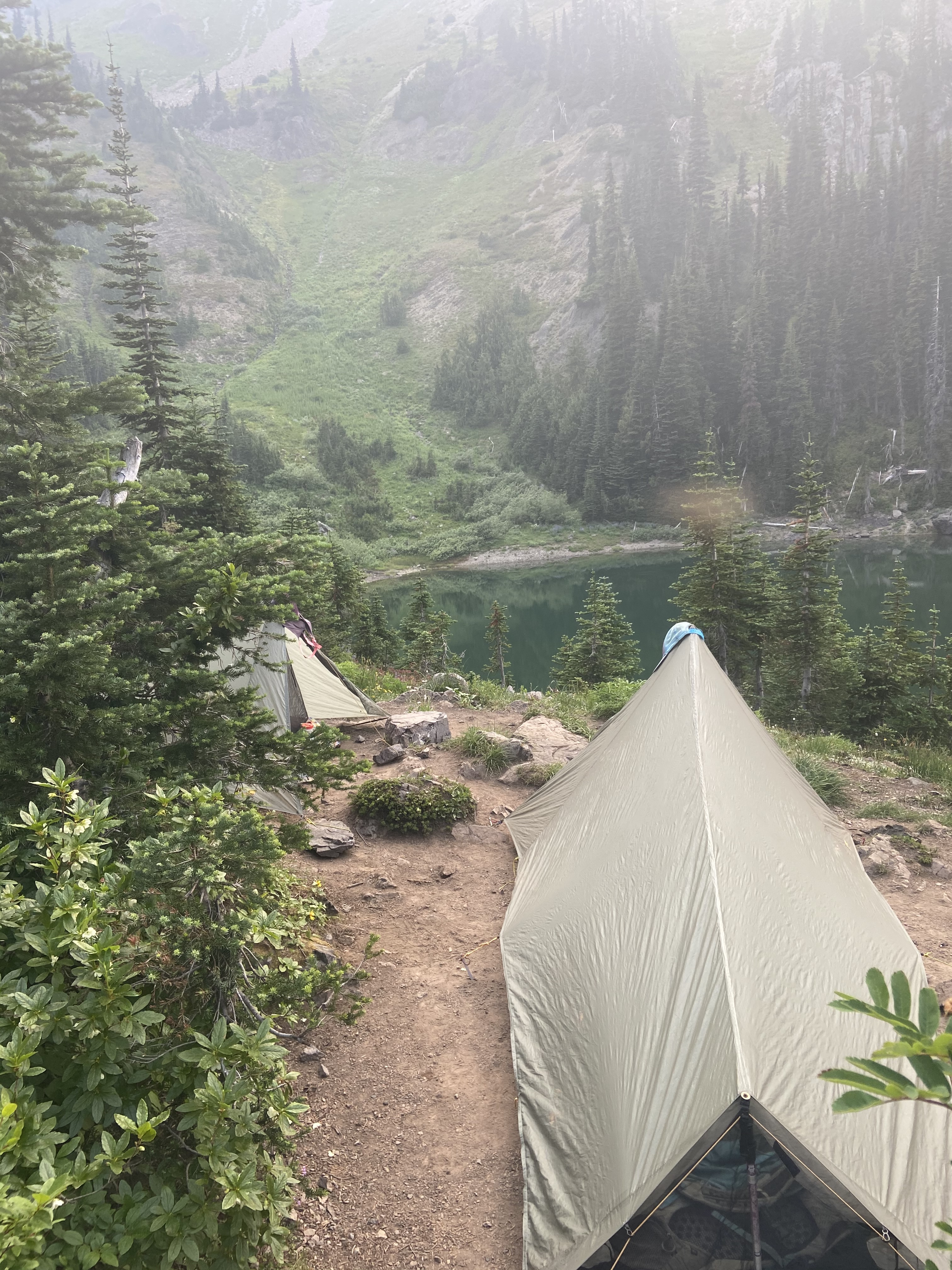 Two small tents by an alpine lake.