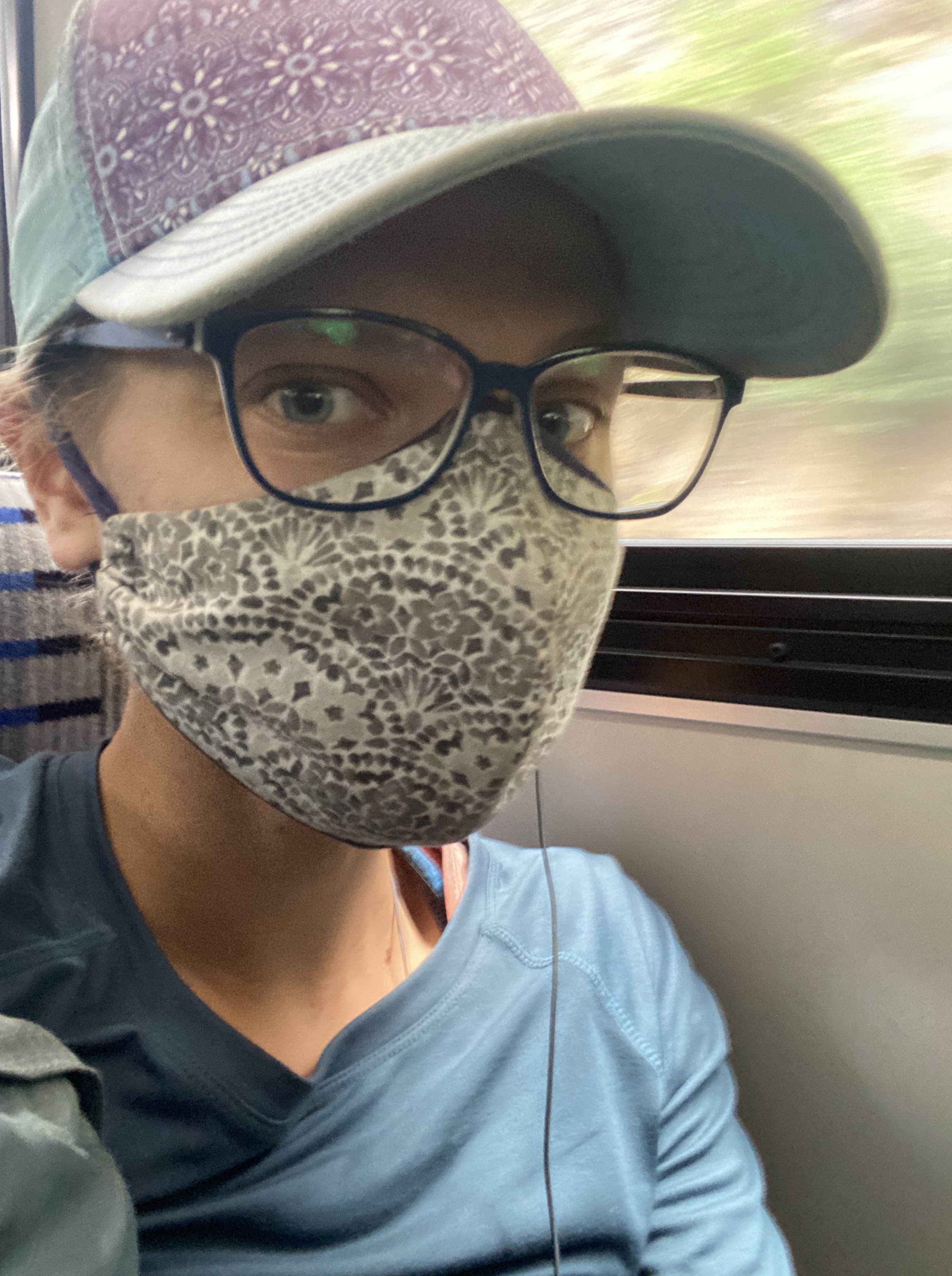 A woman on a bus wearing a face mask.