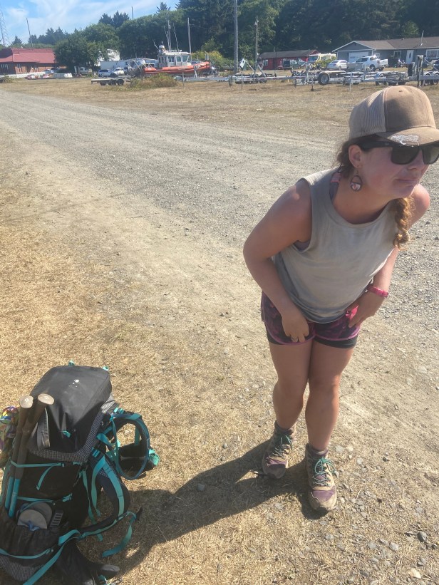 A woman with a backpack beside her and bird poop on her hat.