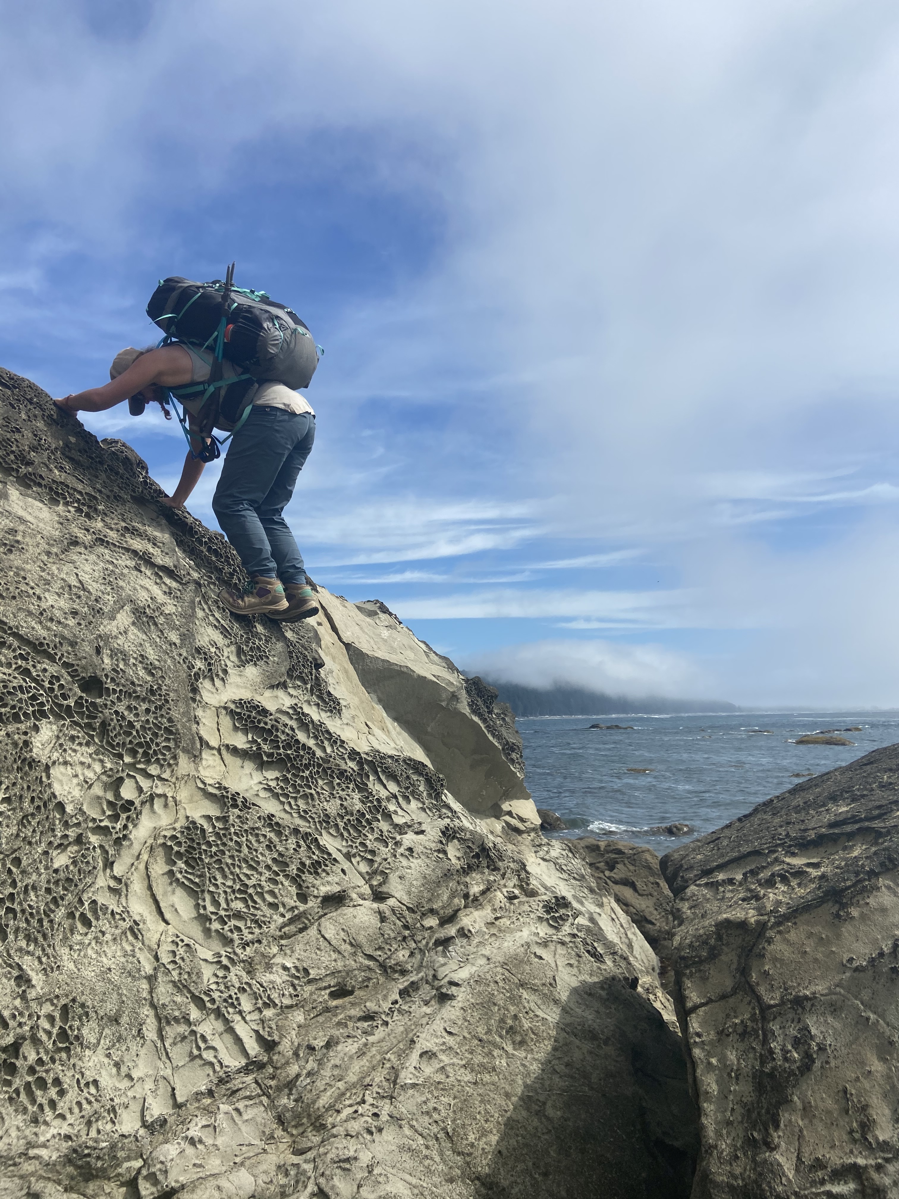 A woman down climbing wearing a backpack.