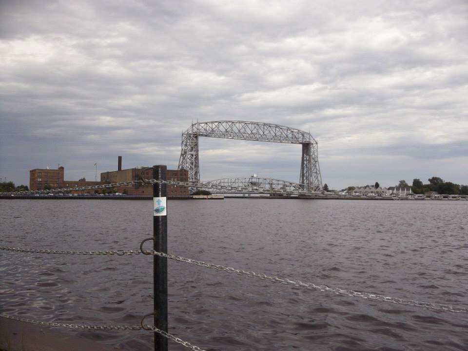 A picture of the Duluth Lift Bridge with a SHT sign in the foreground.