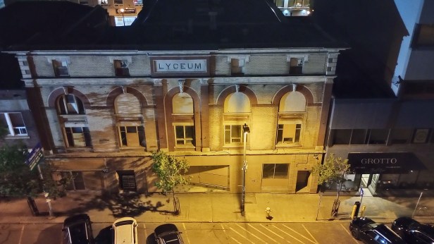 Looking from an upstairs window down on an old looking building with a sign that says "Lyceum".