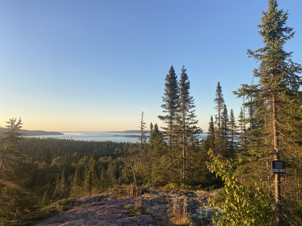 A view of Lake Superior at dawn, with a small sign that says Terrace Heights Lookout.